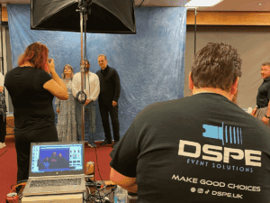 Photographer preparing photo shoot with subjects, equipment in view.