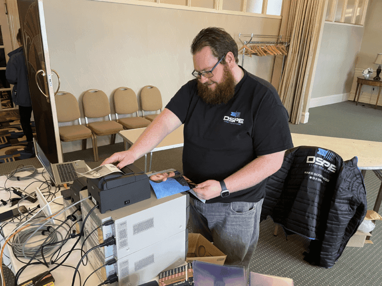 	Man setting up computer equipment at a conference.
