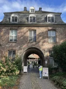 Historic brick building with arched entrance and event signs