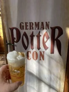 Hand holding beer at German Potter Con event