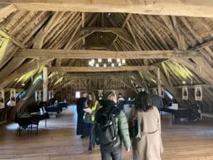 People at exhibition in spacious wooden-beamed attic