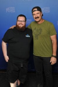 Two smiling men posing at comic convention
