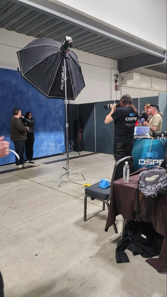 Photographer shooting portrait in studio with blue backdrop