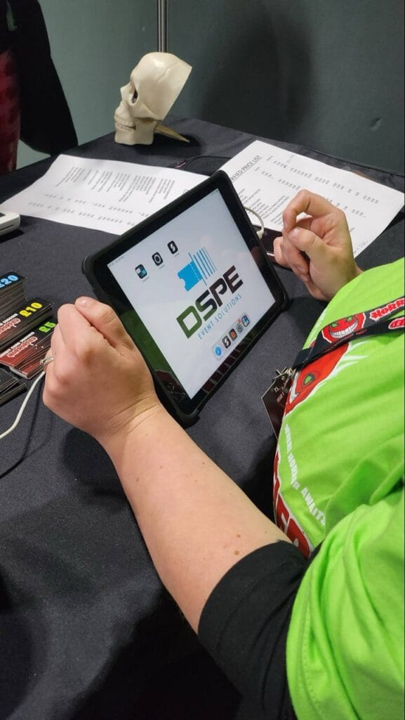 Person examining tablet at event booth