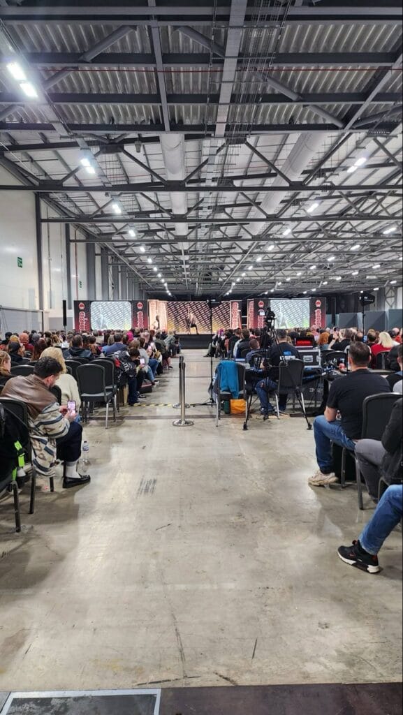 Audience watching a presentation in a large industrial hall