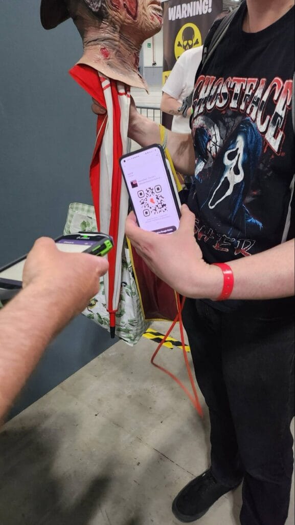 Person scanning QR code on monster costume at event