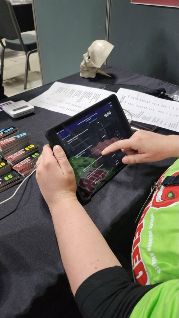 Person using educational app on tablet at booth