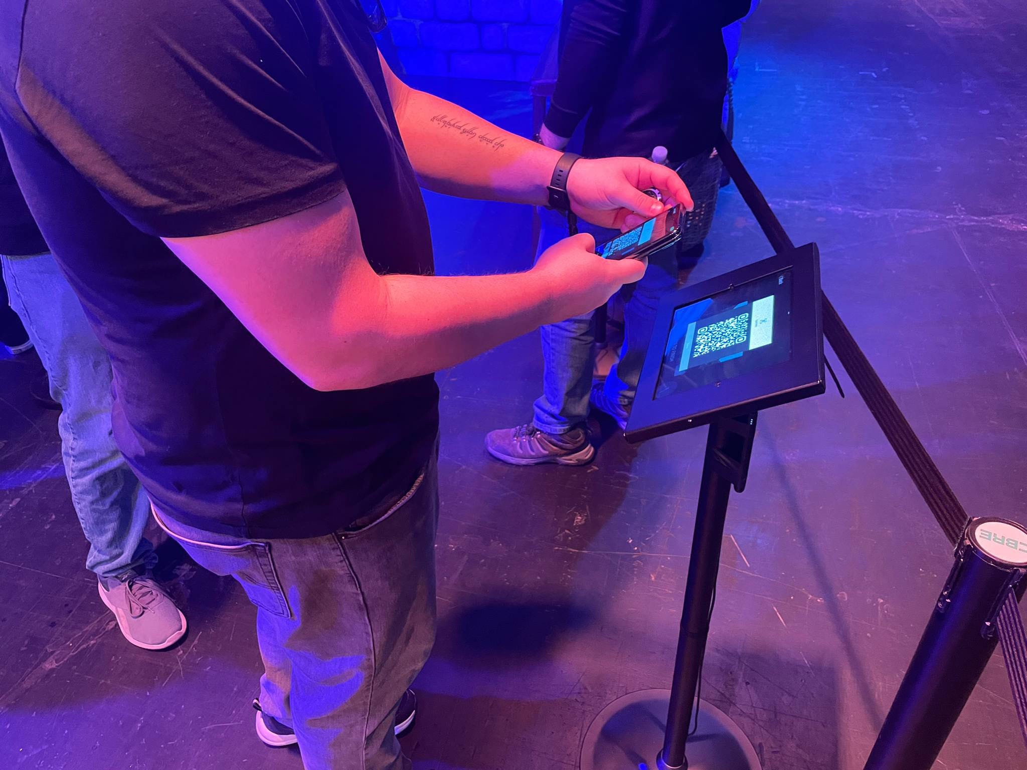 Person scanning QR code on a tablet display.