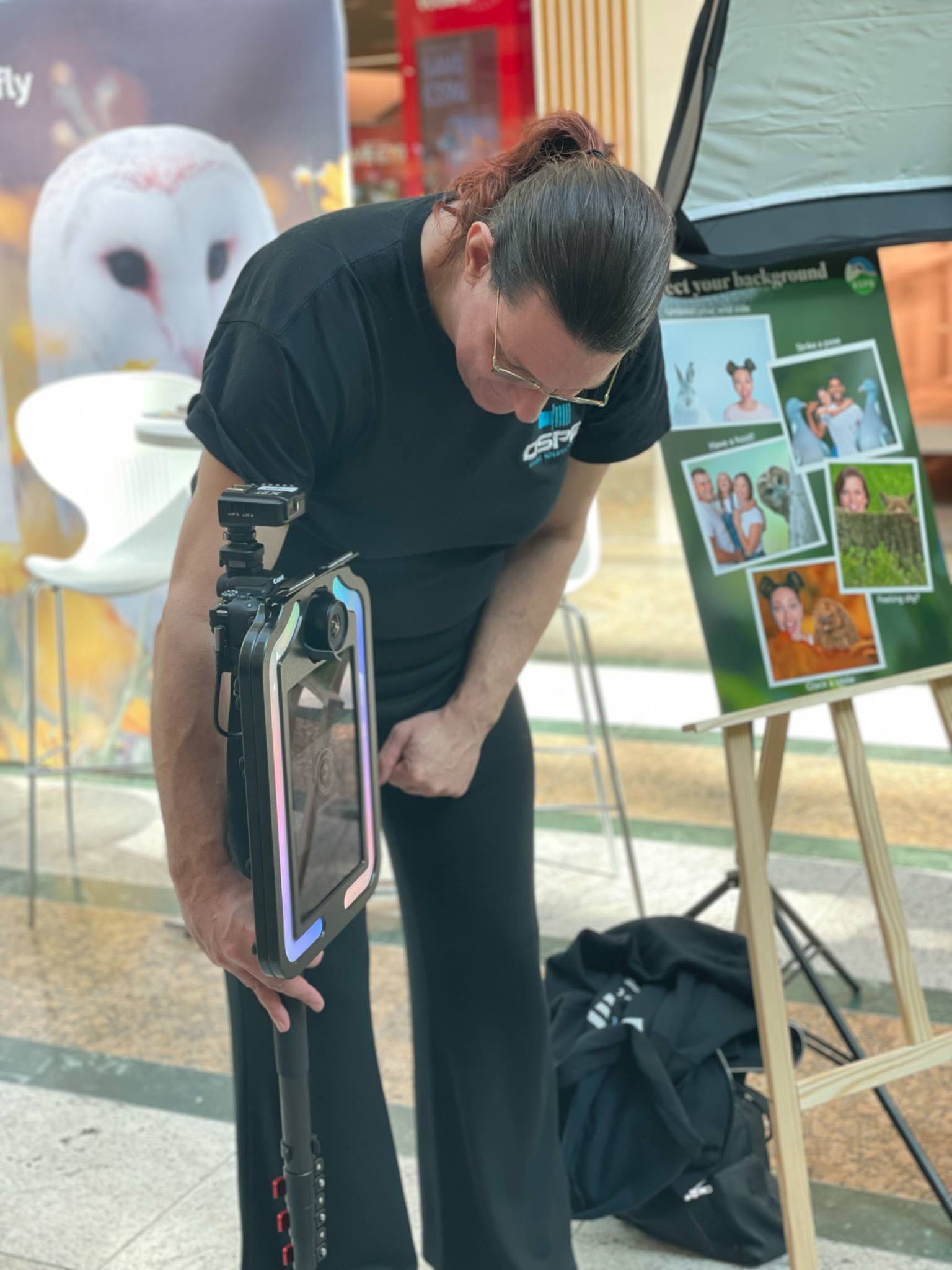 Person setting up camera in shopping centre display.