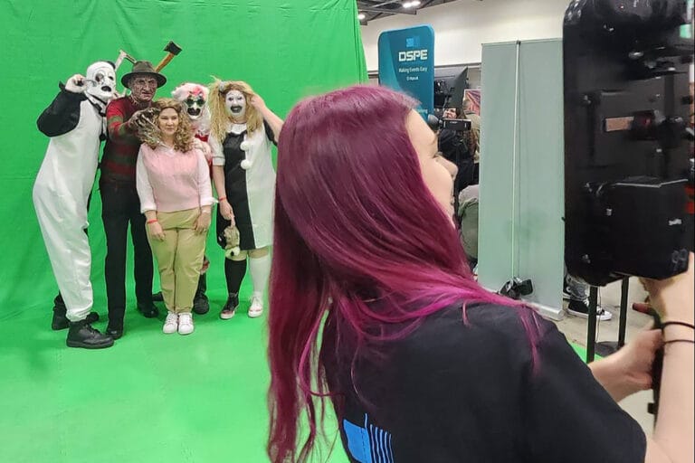 Group in costumes posed before green screen