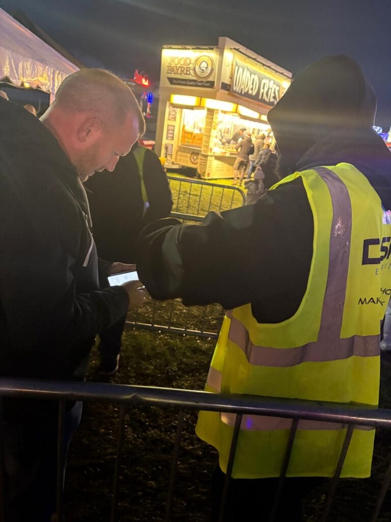 Security checking phone at night food stall