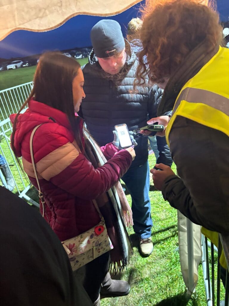 Staff scanning QR code on phone at event