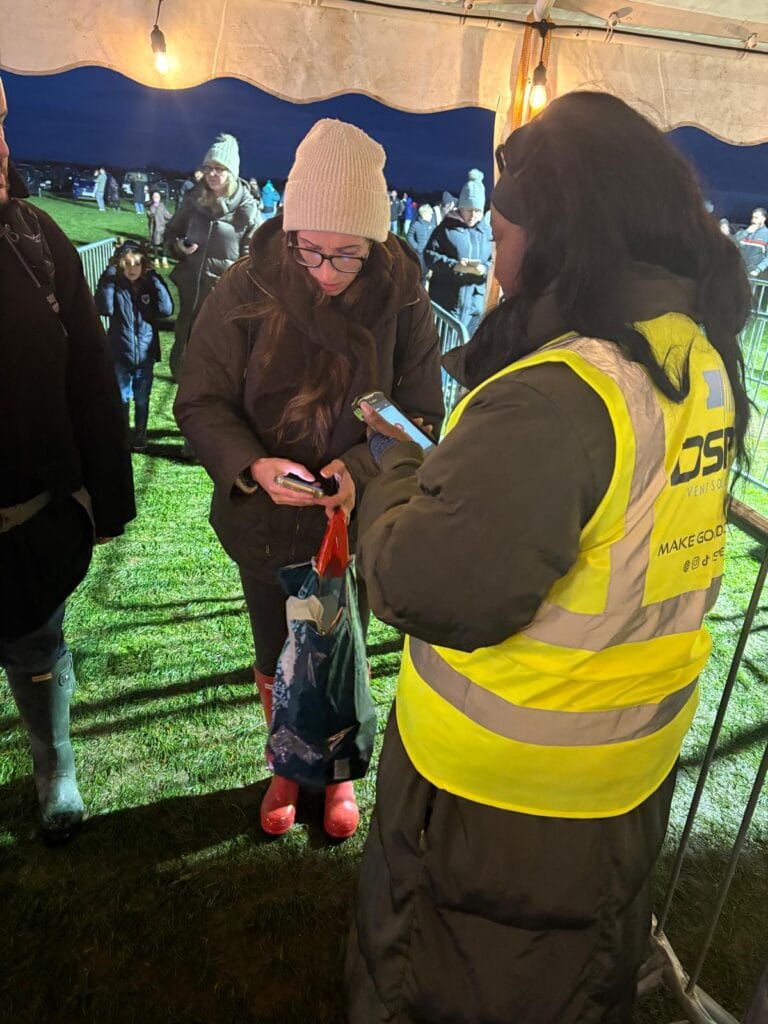 Staff scanning ticket at outdoor night event entrance